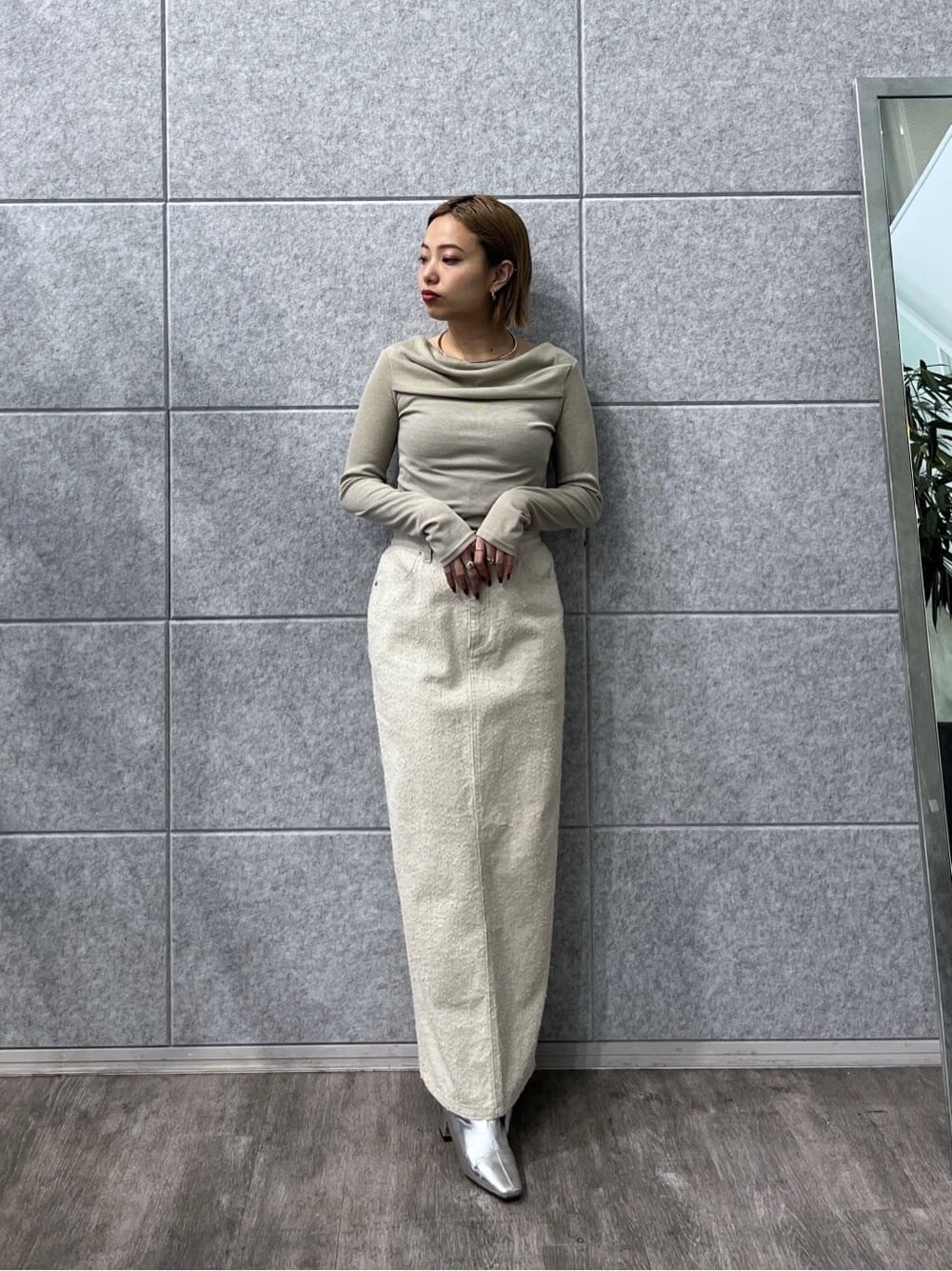 グリーン系のTシャツ/カットソー、ホワイト系のスカートを着用したレディースの冬コーディネートの2枚目の写真