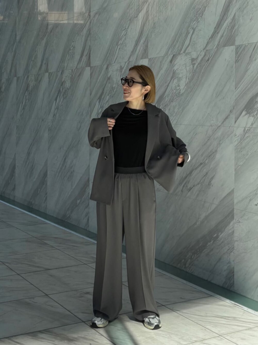 グレー系のその他パンツ、グレー系のテーラードジャケット、ブラック系のTシャツ/カットソーを着用したレディースの春コーディネートの2枚目の写真