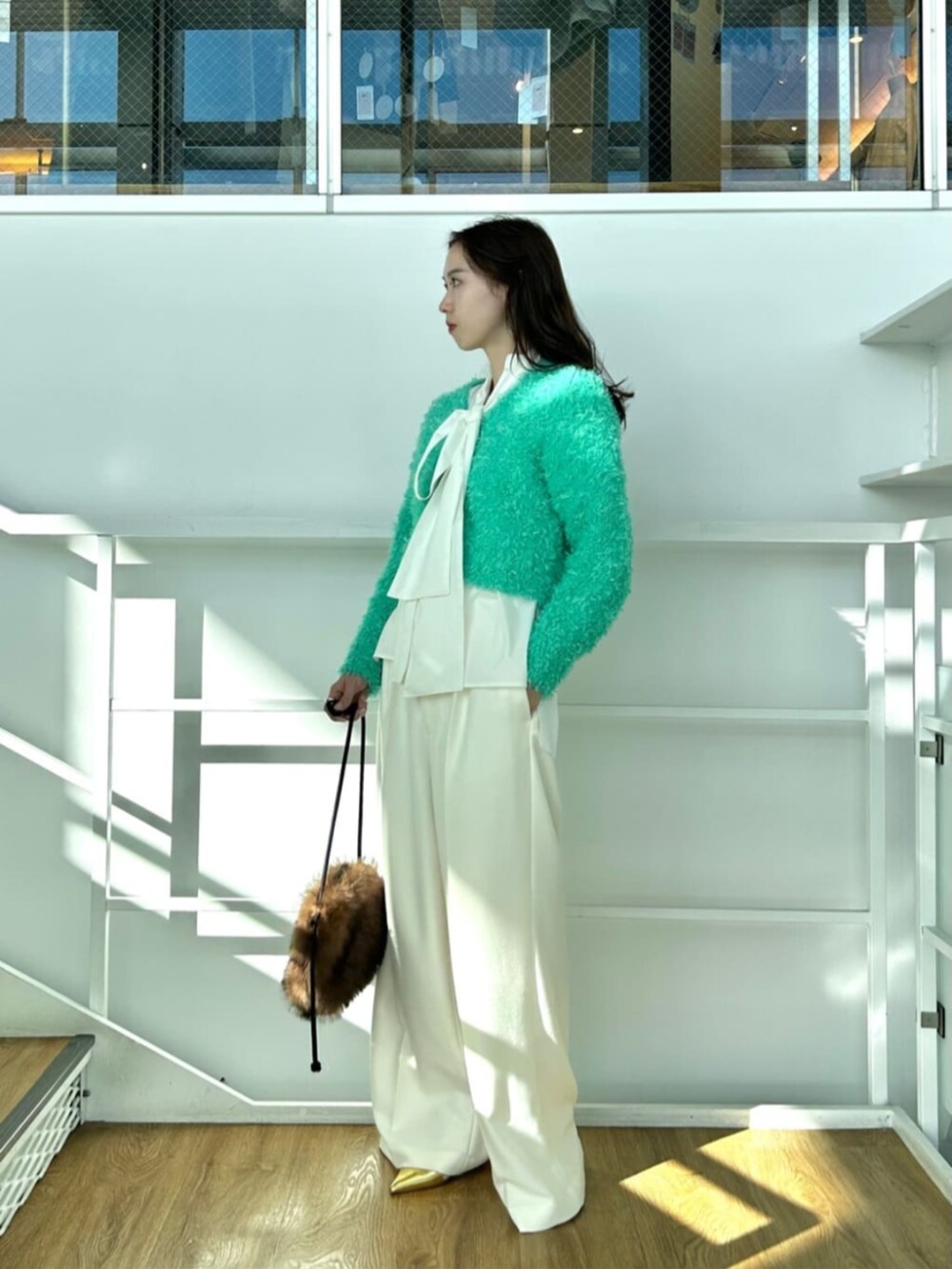 ホワイト系のシャツ/ブラウス、ホワイト系のその他パンツ、グリーン系のカーディガン/ボレロを着用したレディースの冬コーディネートの2枚目の写真