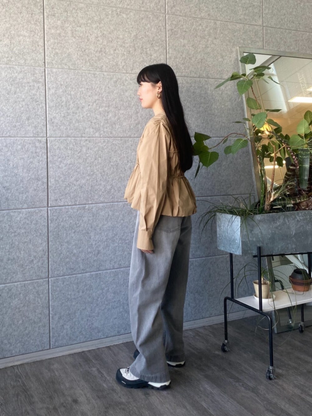 グレー系のデニムパンツ、ベージュ系のシャツ/ブラウスを着用したレディースの春コーディネートの2枚目の写真