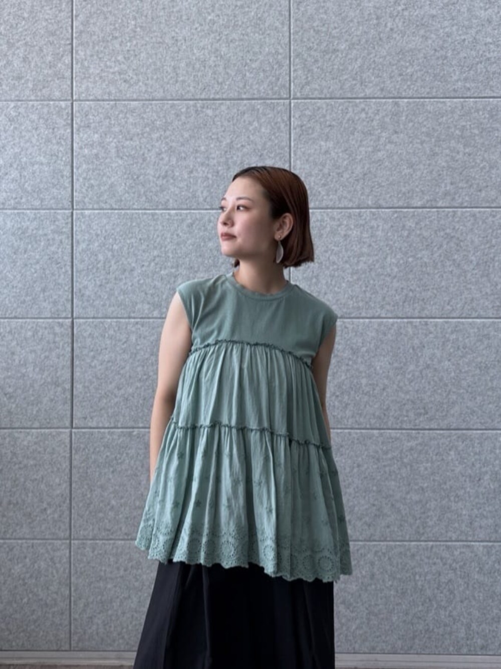 ブラック系のその他パンツ、グリーン系のTシャツ/カットソーを着用したレディースの夏コーディネートの4枚目の写真