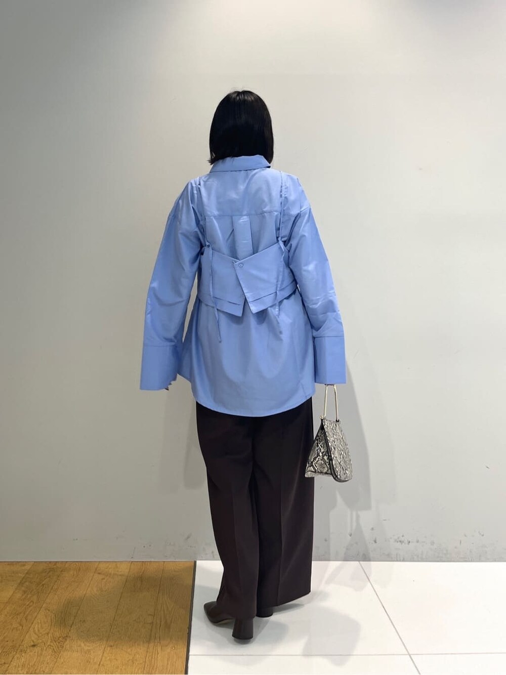 ブルー系のシャツ/ブラウス、ブラウン系のその他パンツ、グレー系のショルダーバッグを着用したレディースの秋コーディネートの3枚目の写真