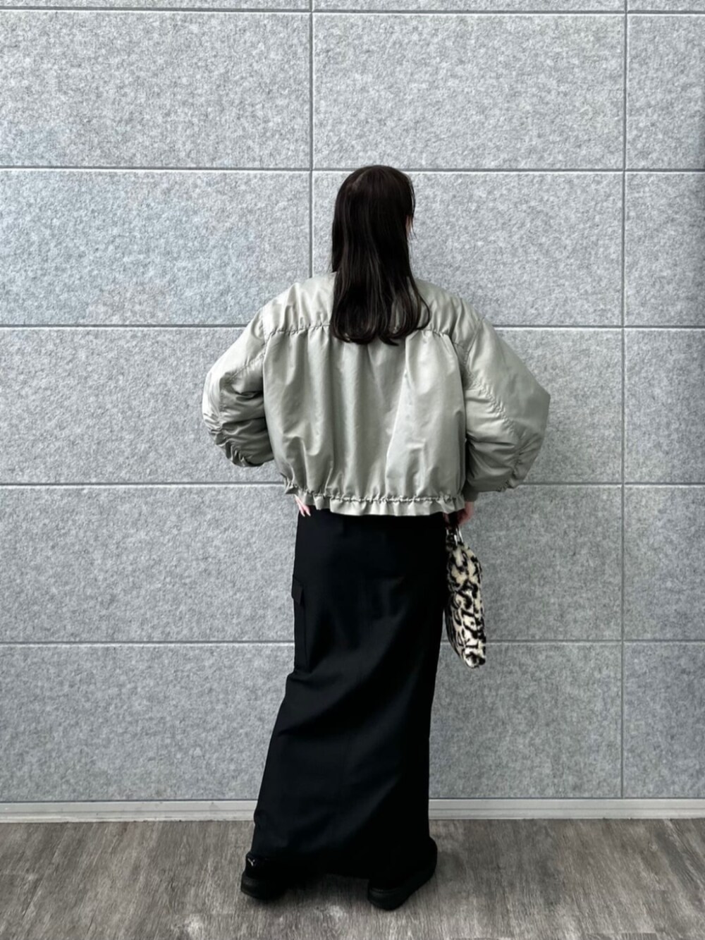 ブラウン系のハンドバッグ、ブラック系のスカート、ブルー系のTシャツ/カットソーを着用したレディースの秋コーディネートの2枚目の写真