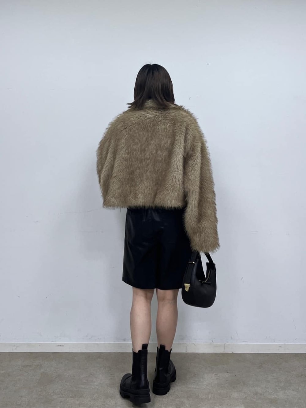 イエロー系のブルゾン、ブラック系のその他パンツ、ブラック系のショルダーバッグを着用したレディースの秋コーディネートの4枚目の写真