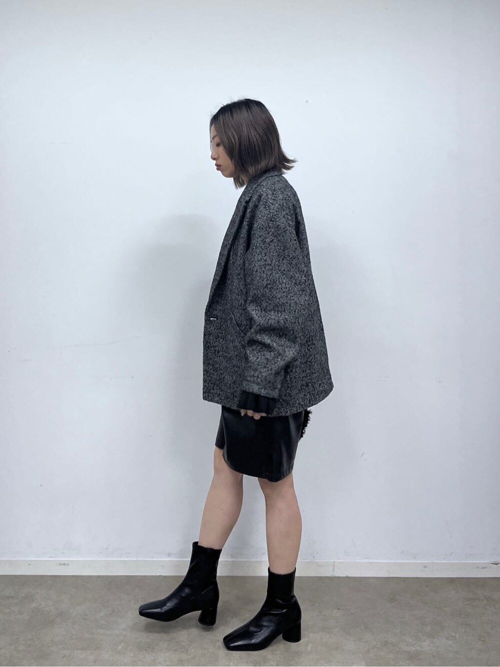 ブラック系のチェスターコート、ブラック系のニット/セーター、ブラック系のその他パンツを着用したレディースの秋コーディネートの3枚目の写真