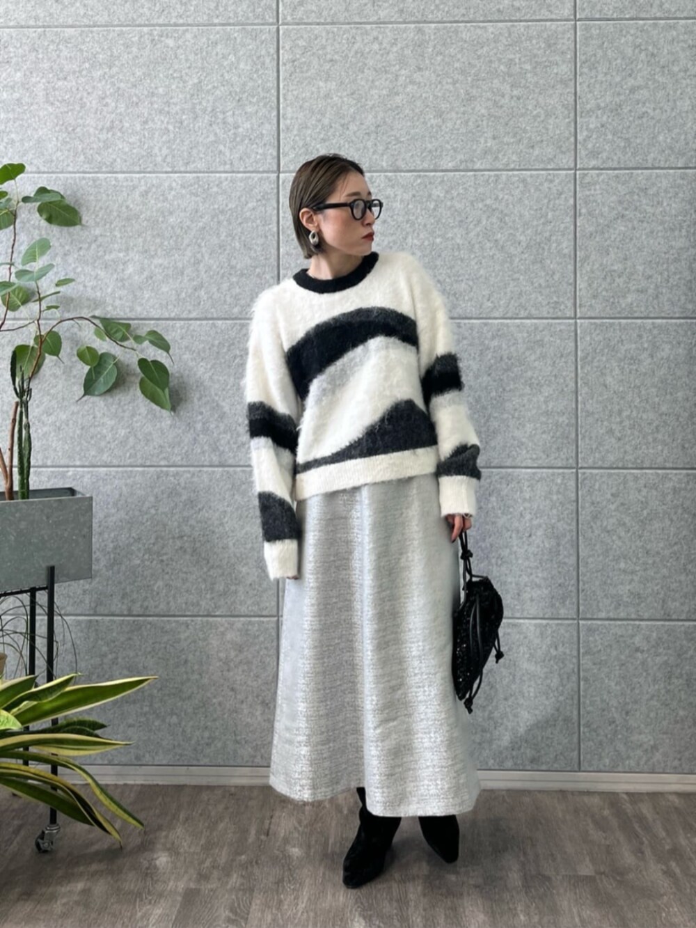 ブラック系のブーツ、ブラック系のその他アウター、グレー系のスカートを着用したレディースの冬コーディネートの2枚目の写真