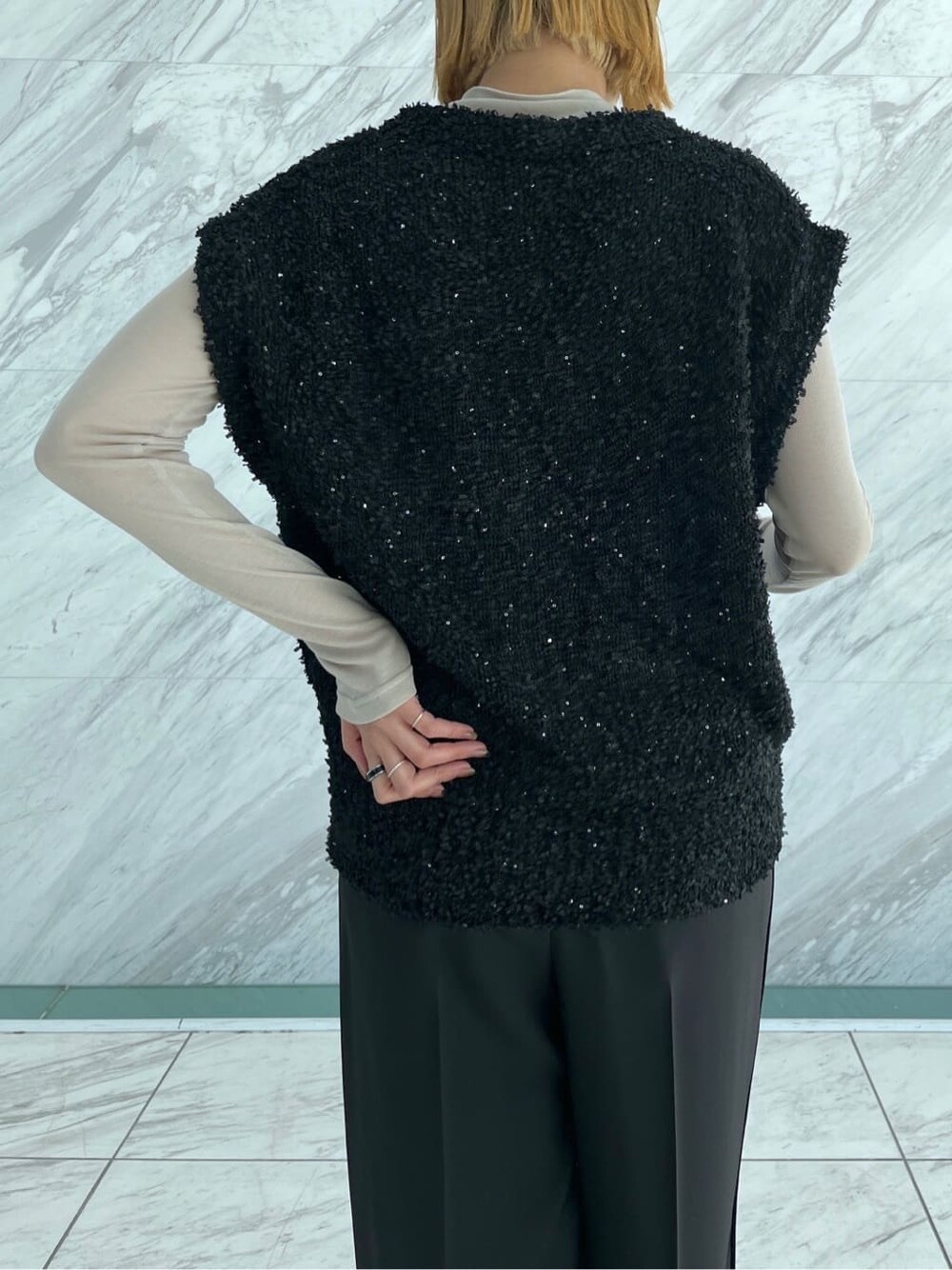 ブラック系のニット/セーター、ベージュ系のTシャツ/カットソー、ブラック系のその他パンツを着用したレディースの冬コーディネートの6枚目の写真