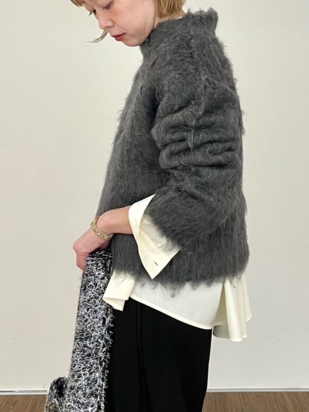 グレー系のニット/セーター、ホワイト系のシャツ/ブラウス、ブラック系のその他パンツを着用したレディースの秋コーディネートの4枚目の写真