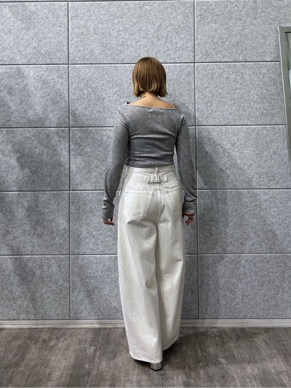 グレー系のTシャツ/カットソー、ホワイト系のデニムパンツを着用したレディースの冬コーディネートの4枚目の写真