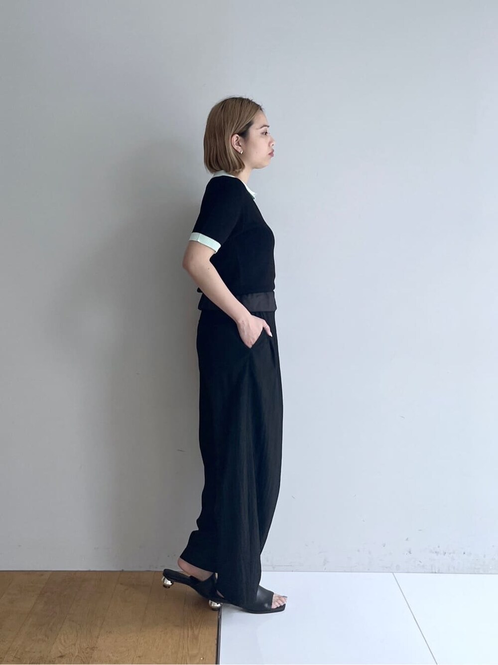 ブラック系のニット/セーター、ブラック系のその他パンツ、ブラック系のサンダルを着用したレディースの春コーディネートの3枚目の写真