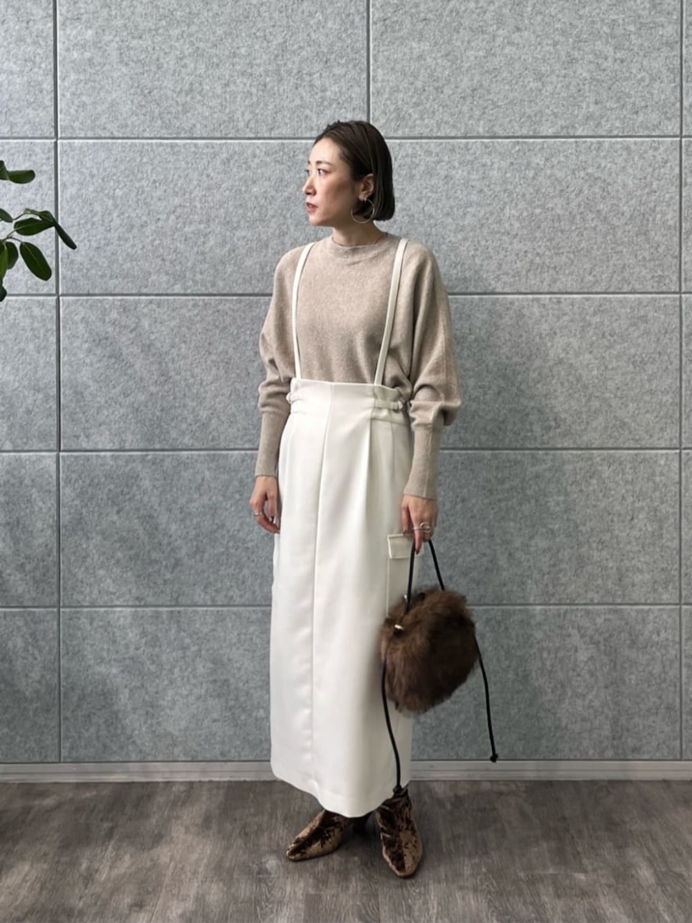 ブラウン系のブーツ、ホワイト系のスカート、ベージュ系のニット/セーターを着用したレディースの冬コーディネートの5枚目の写真
