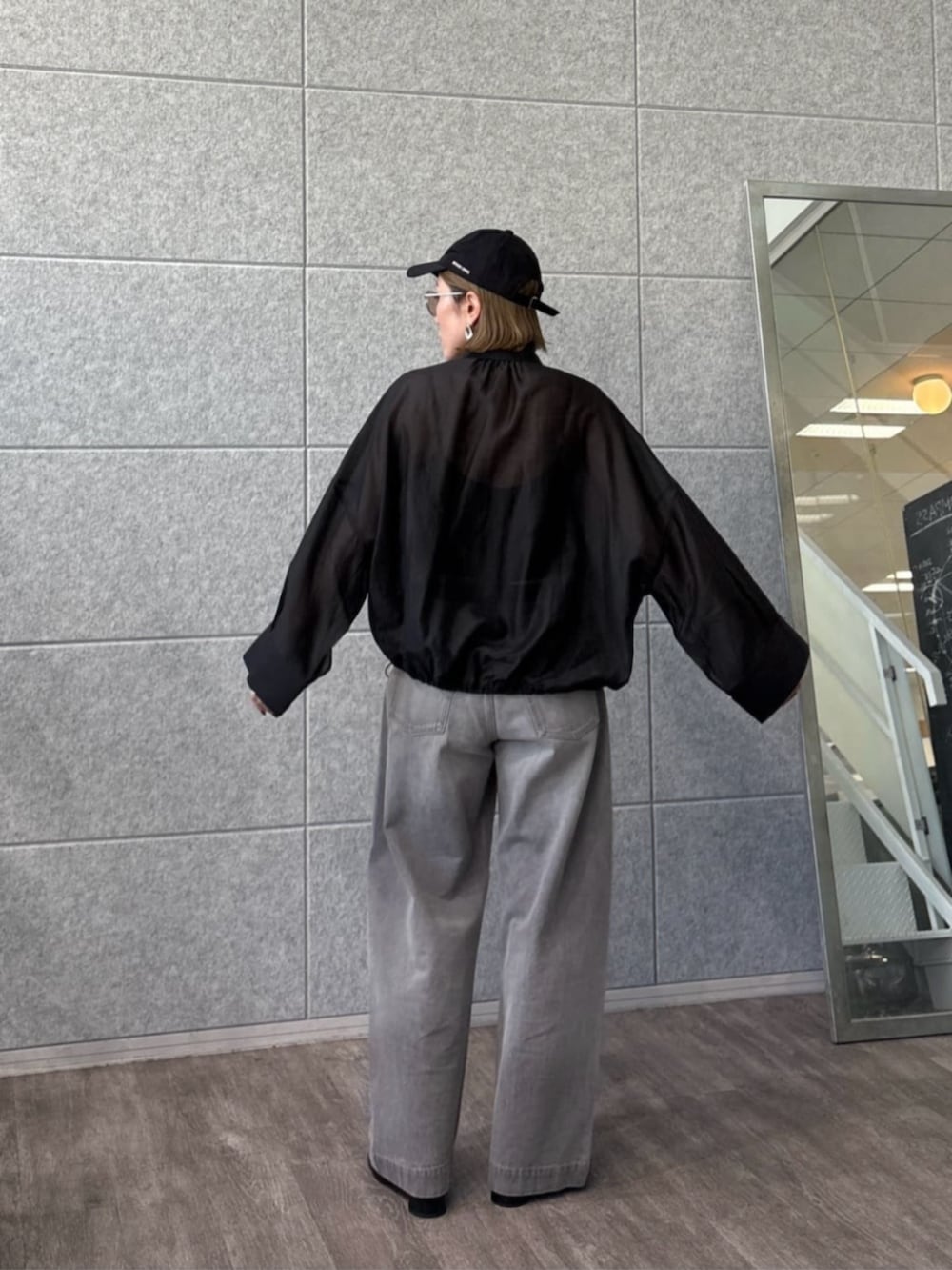 グレー系のデニムパンツ、ブラック系のシャツ/ブラウスを着用したレディースの春コーディネートの3枚目の写真