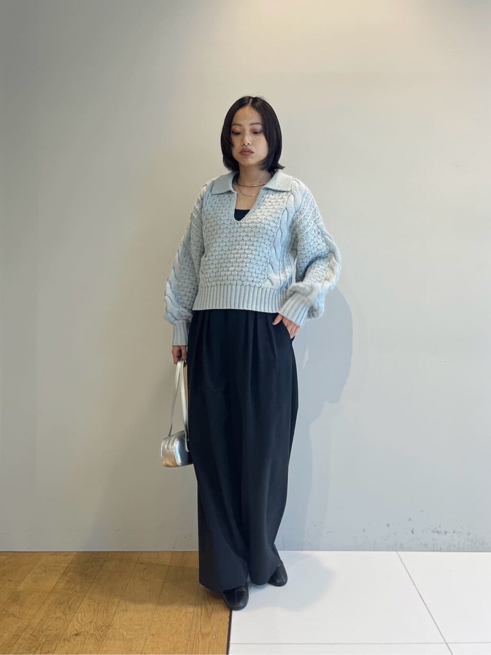 ブルー系のニット/セーター、ブラック系のその他パンツ、シルバー系のハンドバッグを着用したレディースの秋コーディネートの8枚目の写真