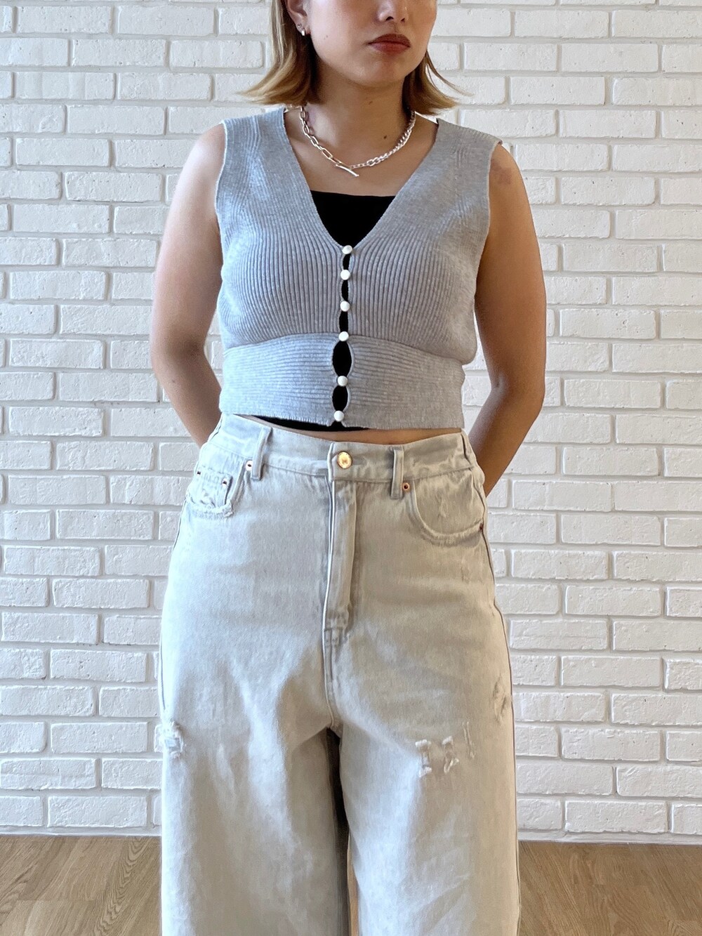 グレー系のニット/セーター、グレー系のデニムパンツを着用したレディースの夏コーディネートの4枚目の写真