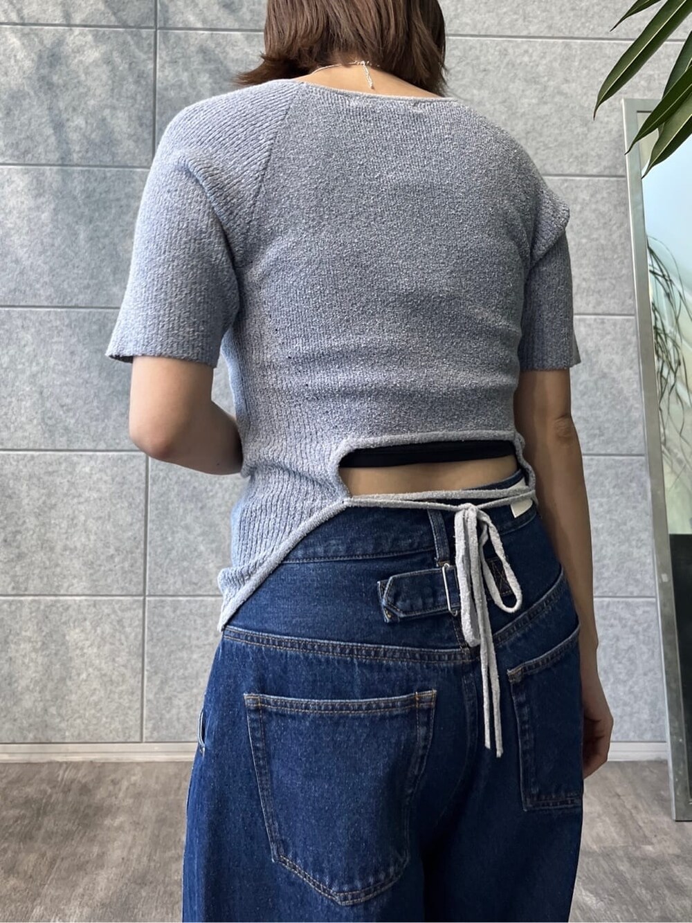 ブルー系のニット/セーター、ブルー系のデニムパンツ、ブラック系のサンダルを着用したレディースの冬コーディネートの6枚目の写真