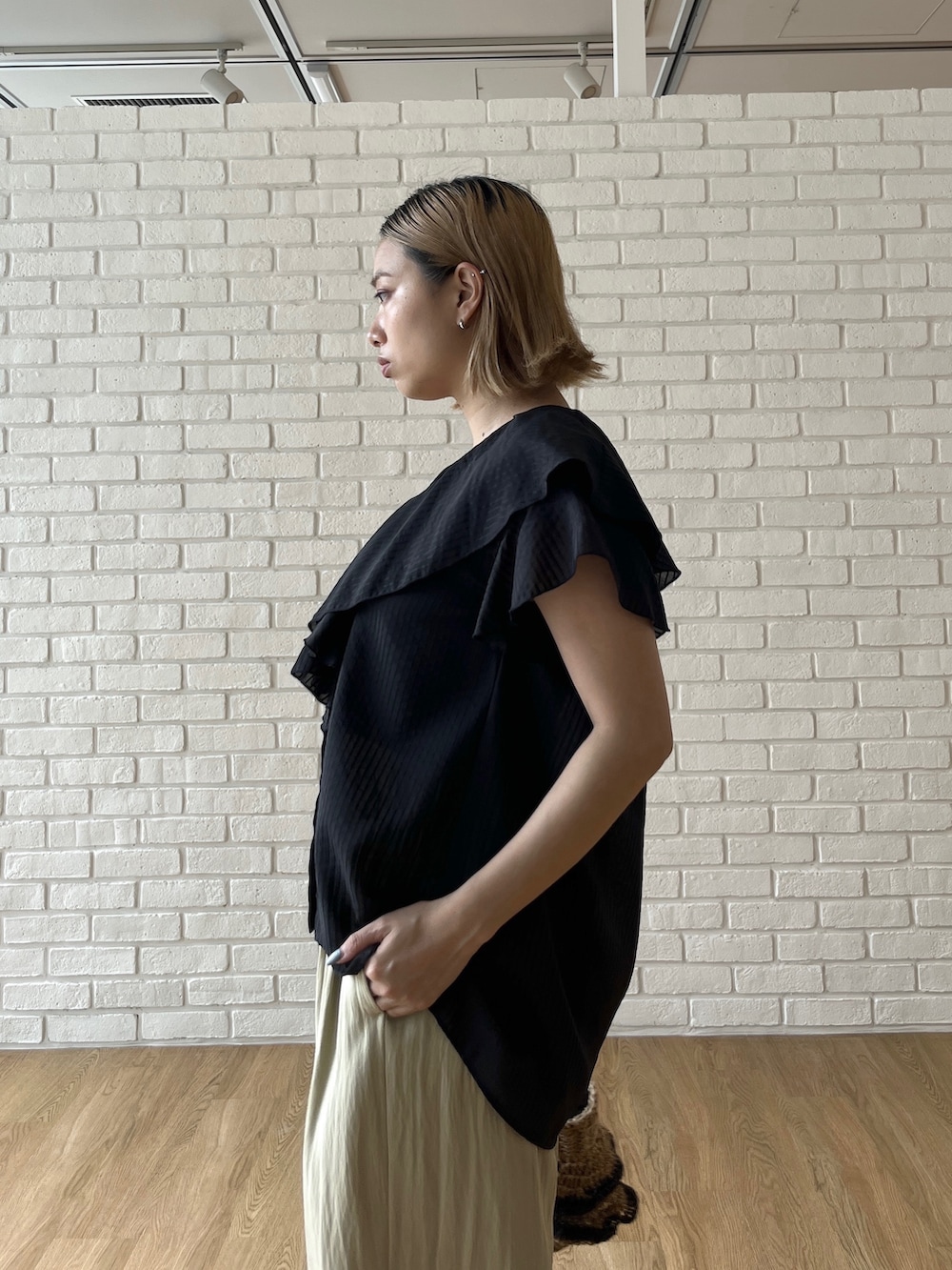 ブラック系のシャツ/ブラウス、グリーン系のその他パンツ、ベージュ系のハンドバッグを着用したレディースの夏コーディネートの6枚目の写真