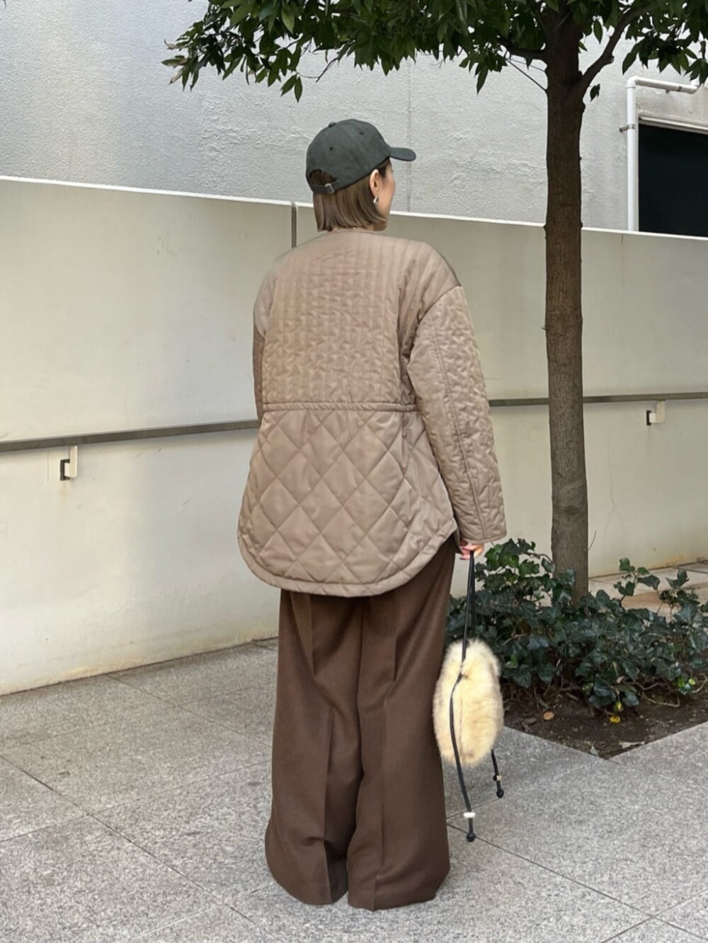 ブラウン系のその他パンツ、グリーン系のその他アウター、ホワイト系のニット/セーターを着用したレディースの冬コーディネートの4枚目の写真