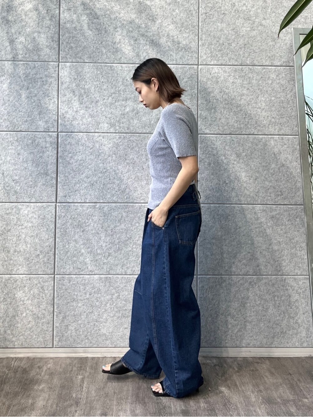ブルー系のニット/セーター、ブルー系のデニムパンツ、ブラック系のサンダルを着用したレディースの冬コーディネートの2枚目の写真