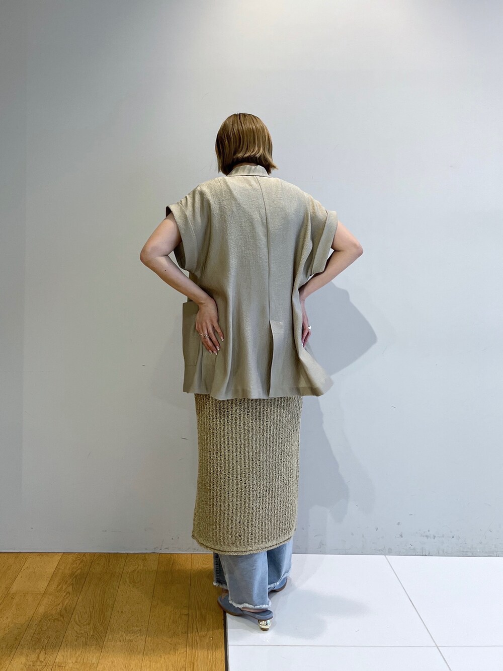 イエロー系のワンピース、ブルー系のデニムパンツ、ブルー系のサンダルを着用したレディースの春コーディネートの4枚目の写真