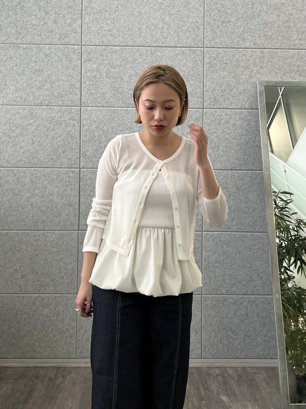 ブルー系のデニムパンツ、ホワイト系のアンサンブルを着用したレディースの春コーディネートの7枚目の写真