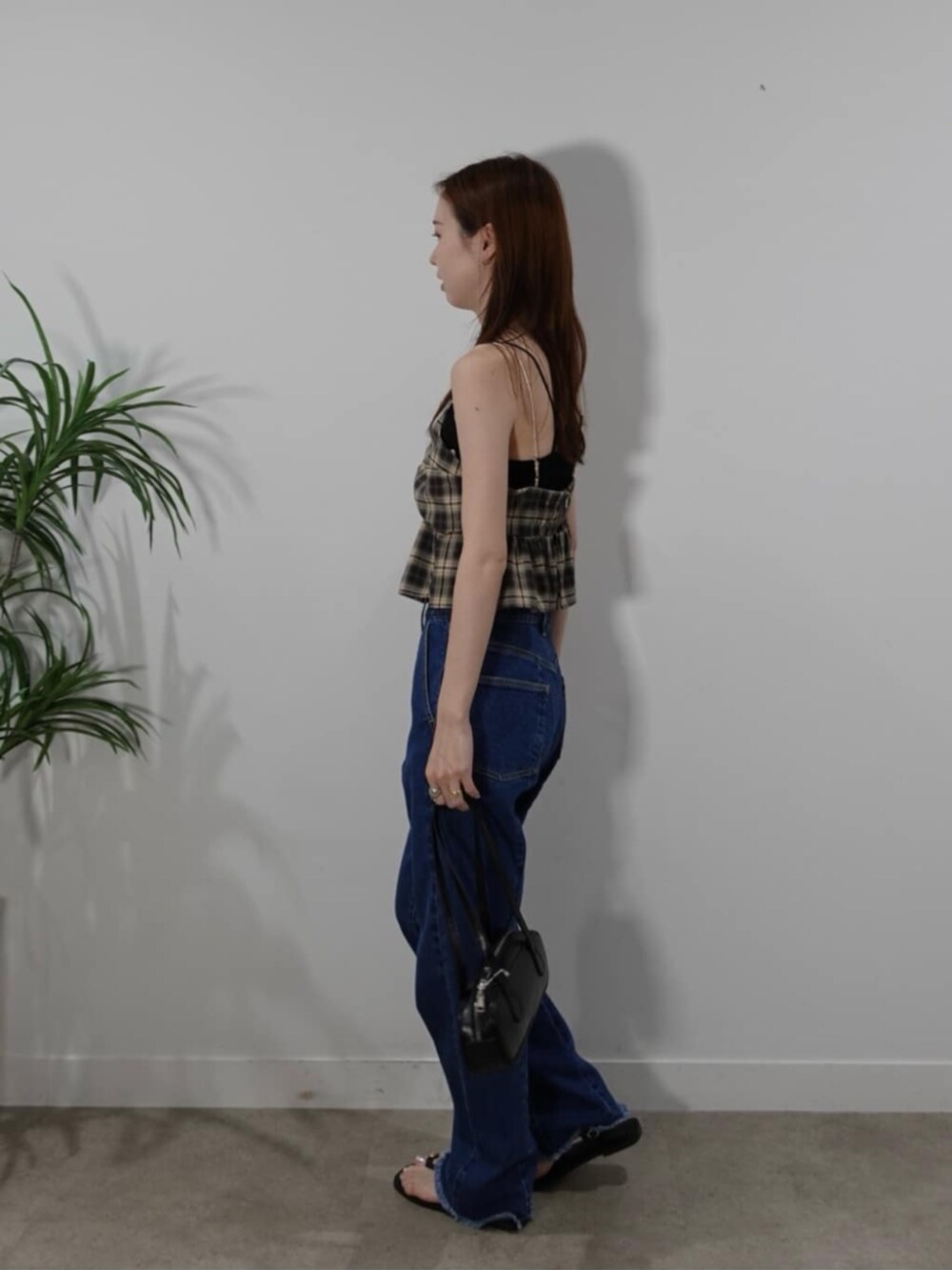 ブルー系のデニムパンツ、ベージュ系のタンクトップを着用したレディースの夏コーディネートの2枚目の写真