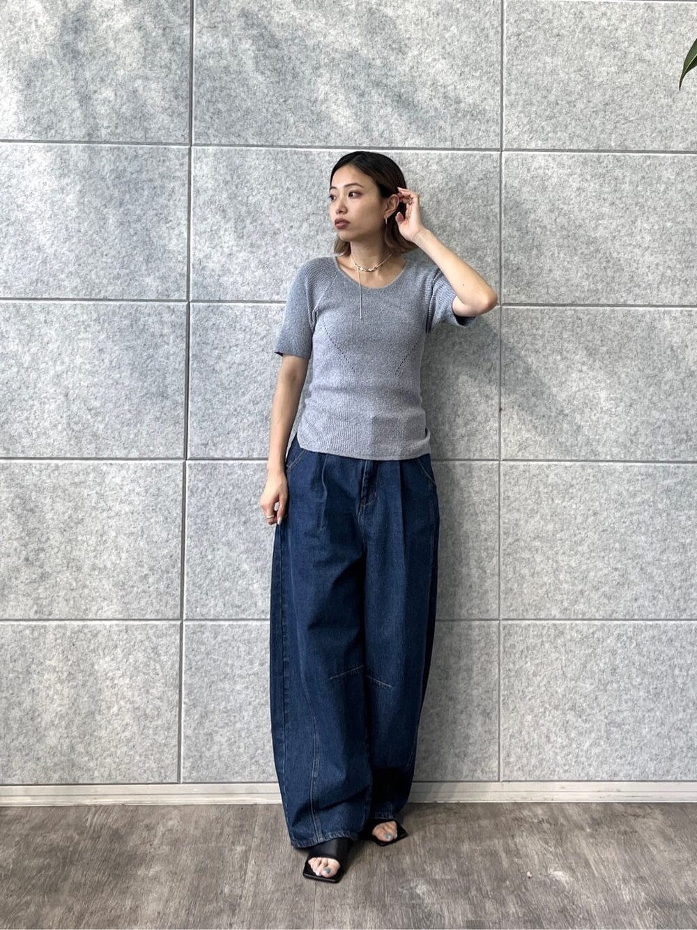 ブルー系のニット/セーター、ブルー系のデニムパンツ、ブラック系のサンダルを着用したレディースの冬コーディネートの8枚目の写真