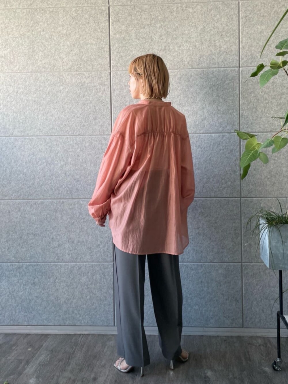 グレー系のその他パンツ、オレンジ系のシャツ/ブラウスを着用したレディースの春コーディネートの3枚目の写真