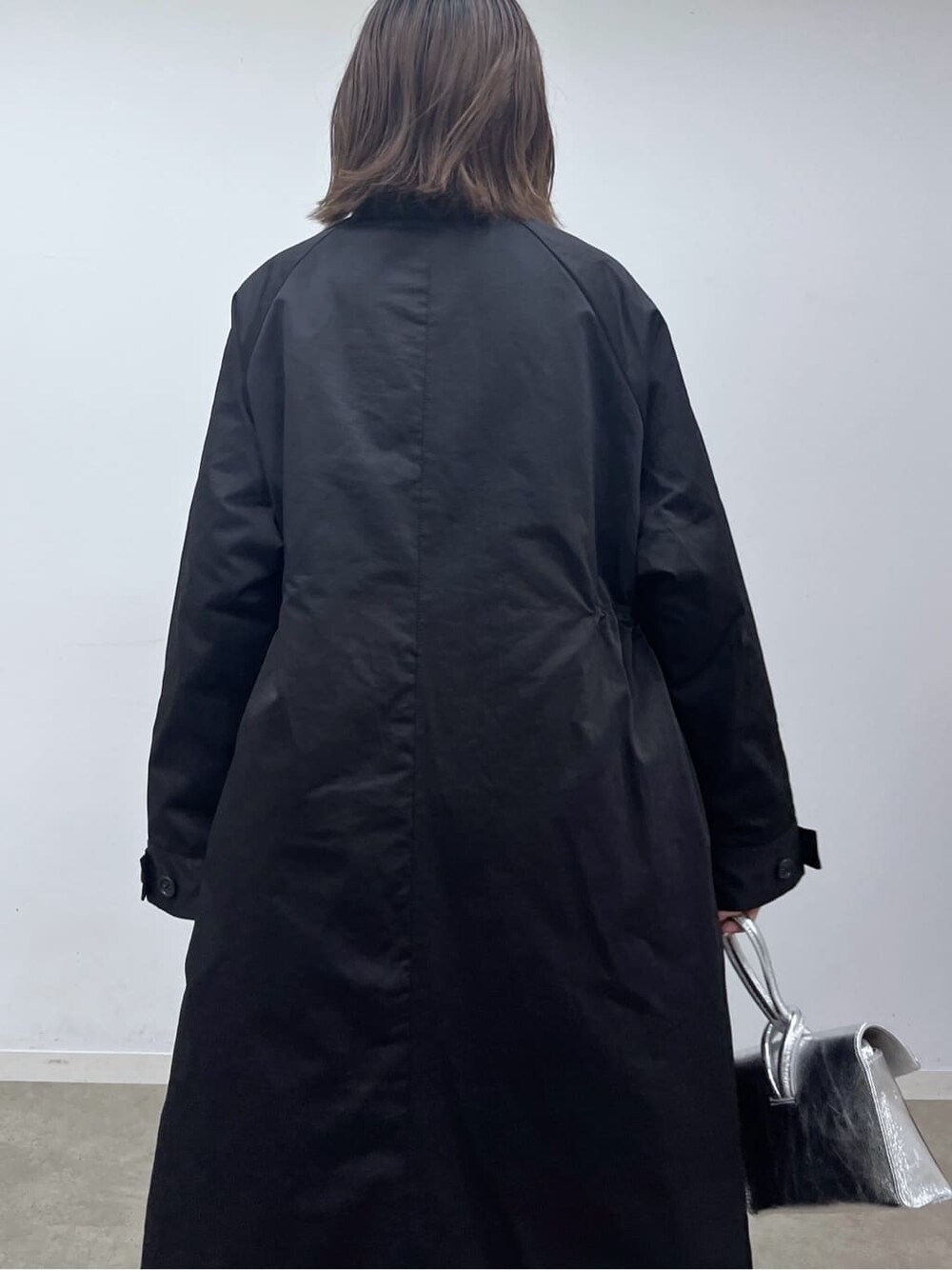 ブラック系のモッズコート、ホワイト系のニット/セーター、ブラック系のその他パンツを着用したレディースの秋コーディネートの7枚目の写真