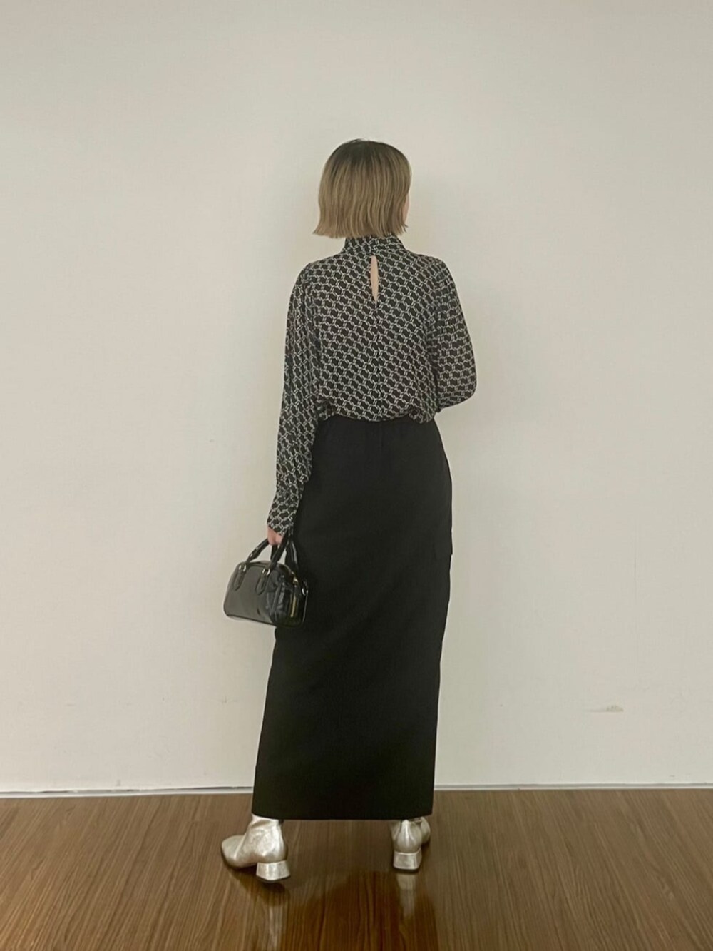 ブラック系のスカート、ブラック系のシャツ/ブラウスを着用したレディースの秋コーディネートの2枚目の写真