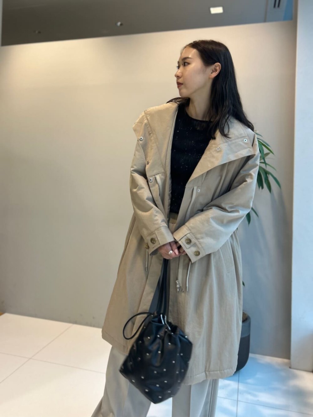 ブラック系のニット/セーター、ベージュ系のその他パンツ、ベージュ系のその他アウターを着用したレディースの秋コーディネートの3枚目の写真