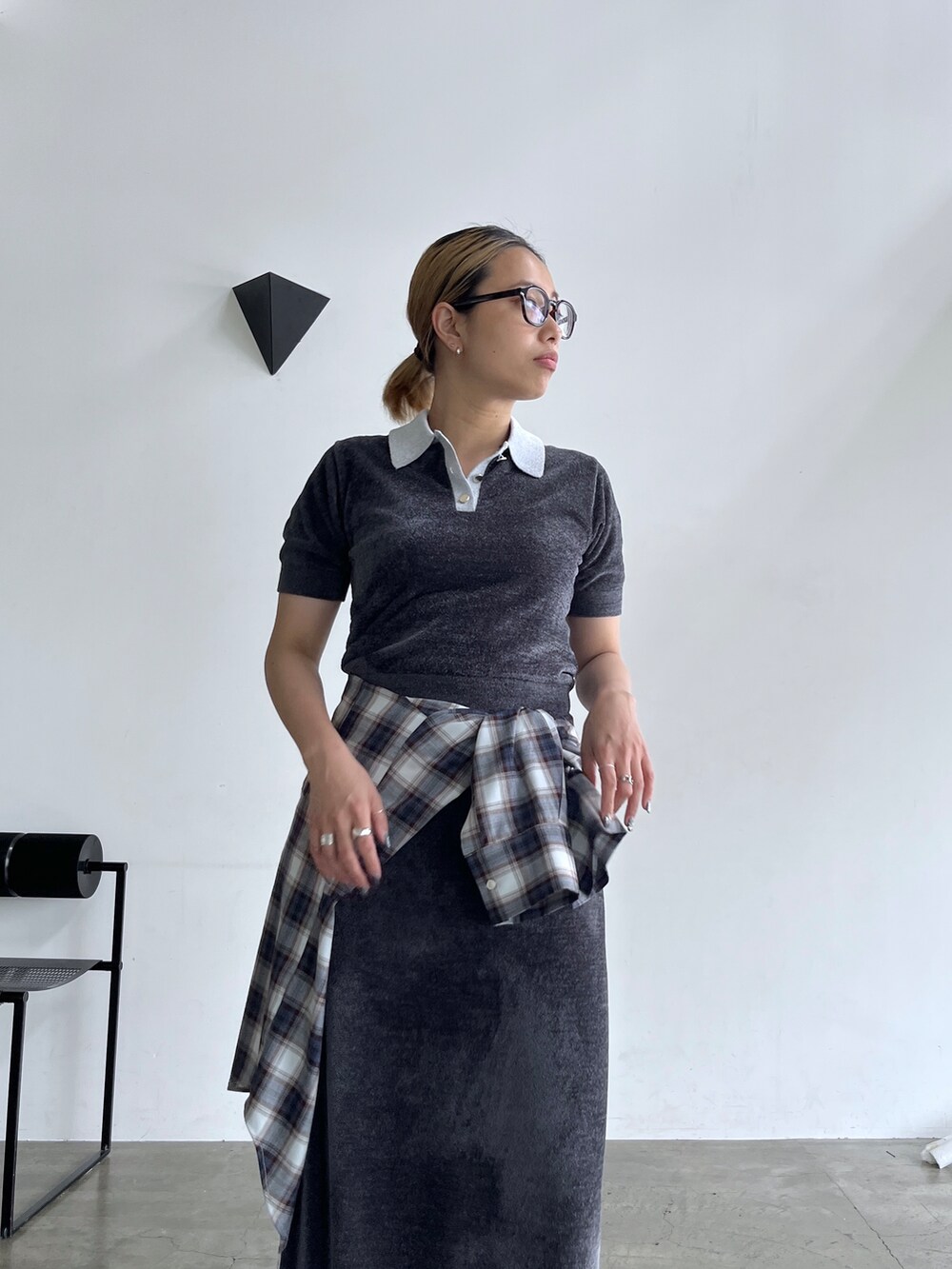 グレー系のニット/セーター、グレー系のスカート、ブルー系のシャツ/ブラウスを着用したレディースの夏コーディネートの6枚目の写真