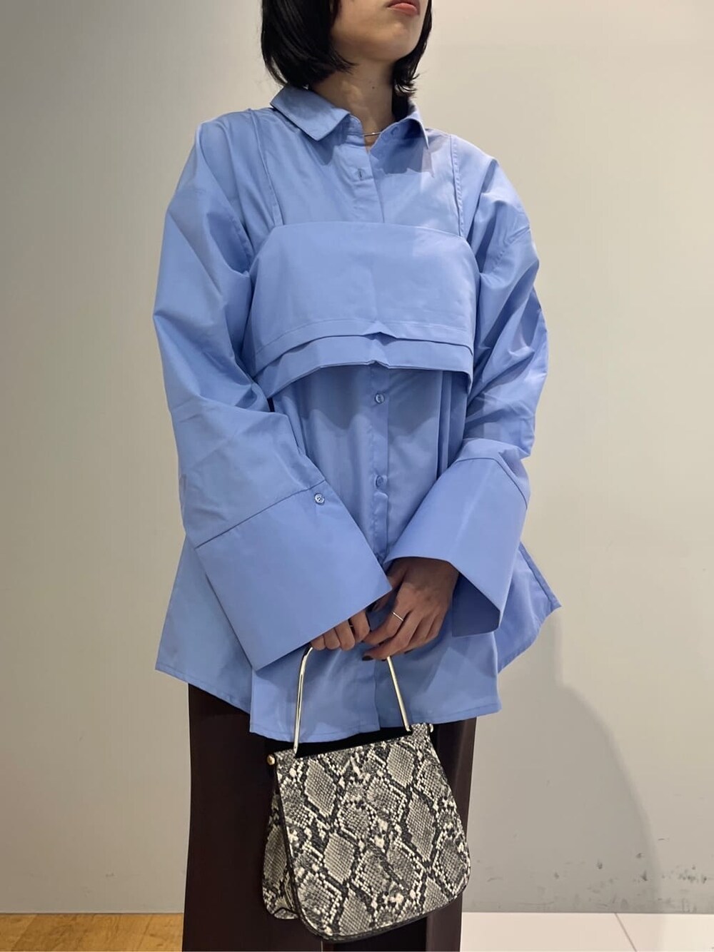 ブルー系のシャツ/ブラウス、ブラウン系のその他パンツ、グレー系のショルダーバッグを着用したレディースの秋コーディネートの4枚目の写真