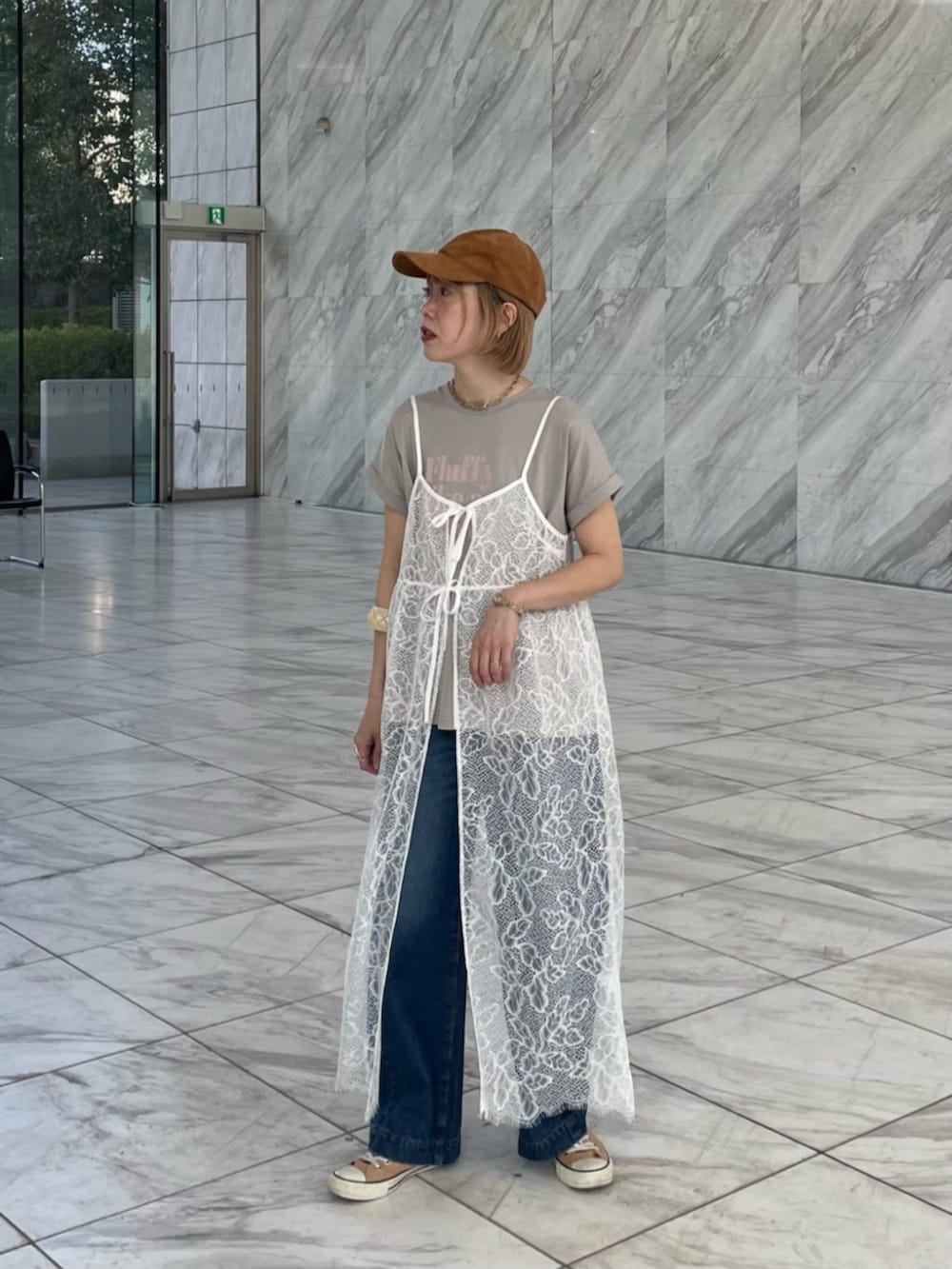 ブルー系のデニムパンツ、グレー系のTシャツ/カットソー、ホワイト系のワンピースを着用したレディースの春コーディネートの2枚目の写真