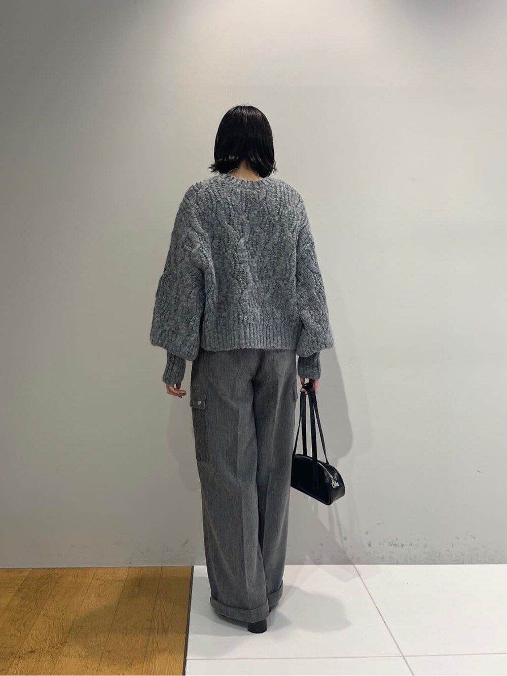 グレー系のニット/セーター、グレー系のその他パンツ、ブラック系のハンドバッグを着用したレディースの秋コーディネートの4枚目の写真