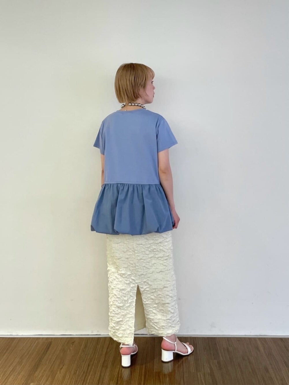 ホワイト系のスカート、ブルー系のTシャツ/カットソー、シルバー系のネックレスを着用したレディースの春コーディネートの4枚目の写真