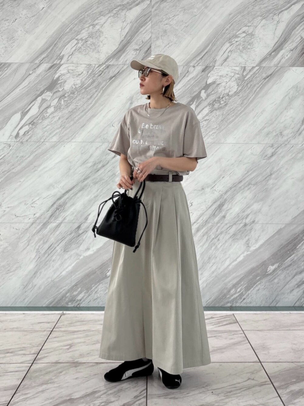 ホワイト系のTシャツ/カットソー、グリーン系のスカートを着用したレディースの春コーディネートの2枚目の写真