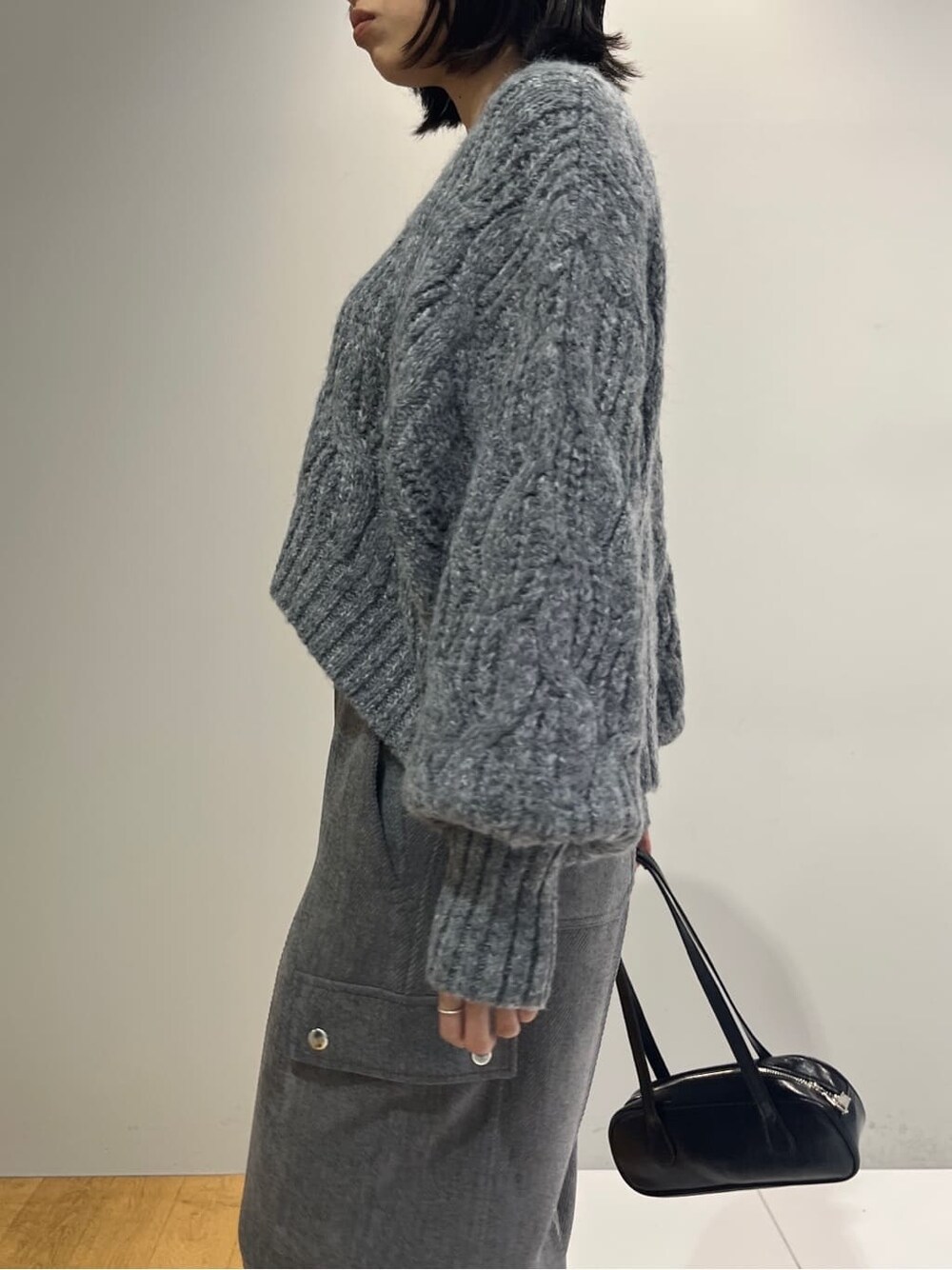 グレー系のニット/セーター、グレー系のその他パンツ、ブラック系のハンドバッグを着用したレディースの秋コーディネートの6枚目の写真