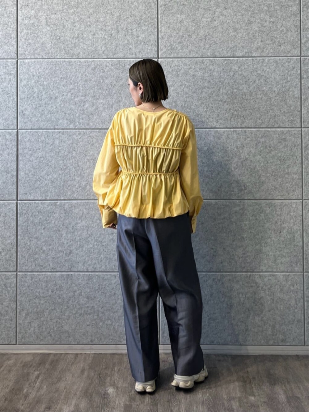グレー系のその他パンツ、イエロー系のシャツ/ブラウスを着用したレディースの冬コーディネートの2枚目の写真