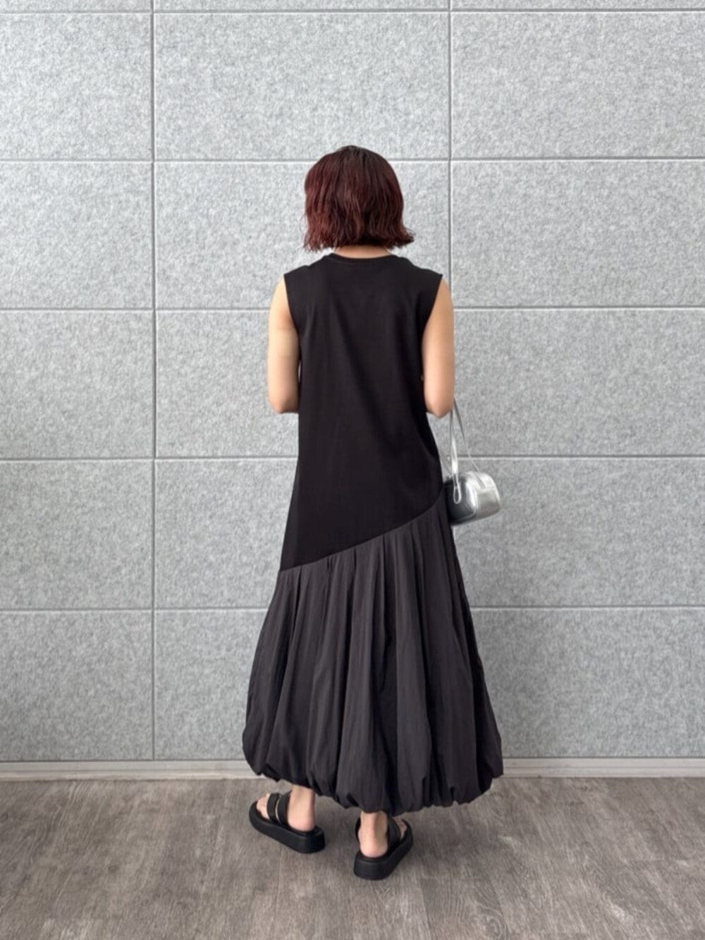 ブラック系のサンダル、シルバー系のハンドバッグ、ブラック系のワンピースを着用したレディースの夏コーディネートの3枚目の写真