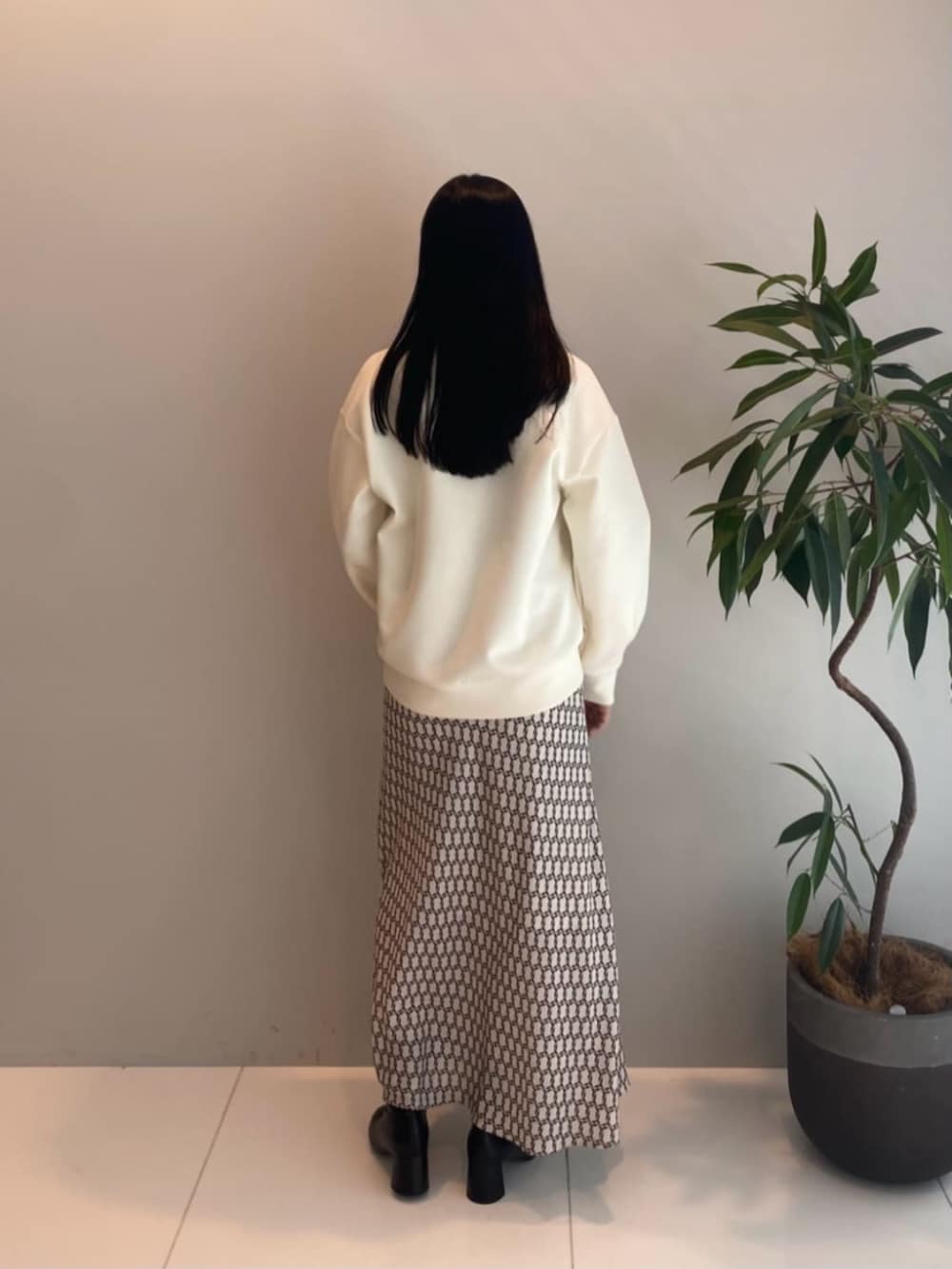 ベージュ系のスカート、ホワイト系のTシャツ/カットソーを着用したレディースの秋コーディネートの2枚目の写真