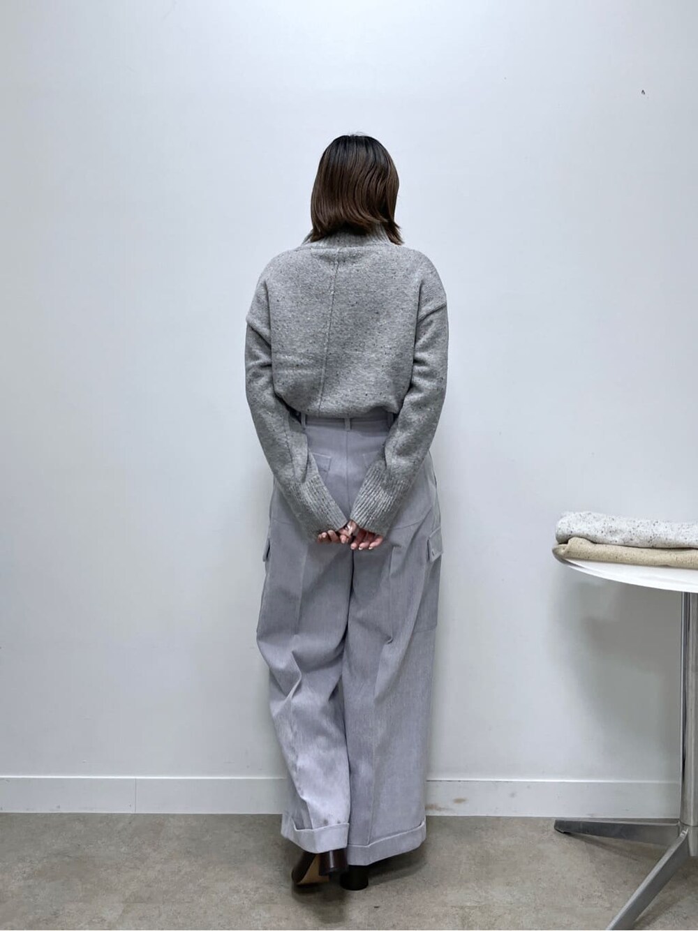 グレー系のニット/セーター、パープル系のその他パンツを着用したレディースの冬コーディネートの4枚目の写真