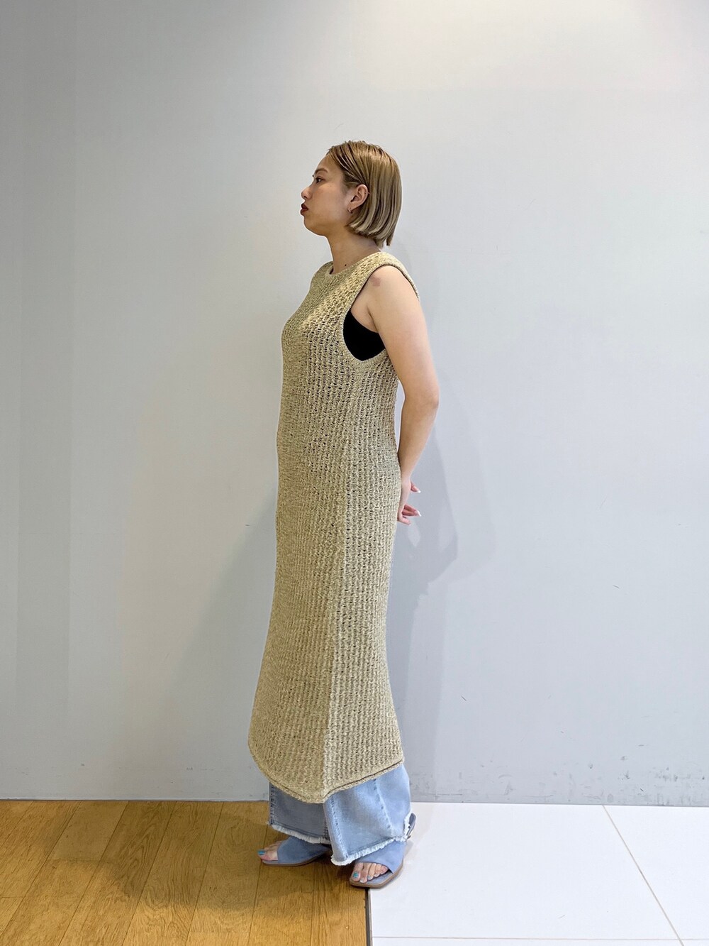 イエロー系のワンピース、ブルー系のデニムパンツ、ブルー系のサンダルを着用したレディースの春コーディネートの10枚目の写真