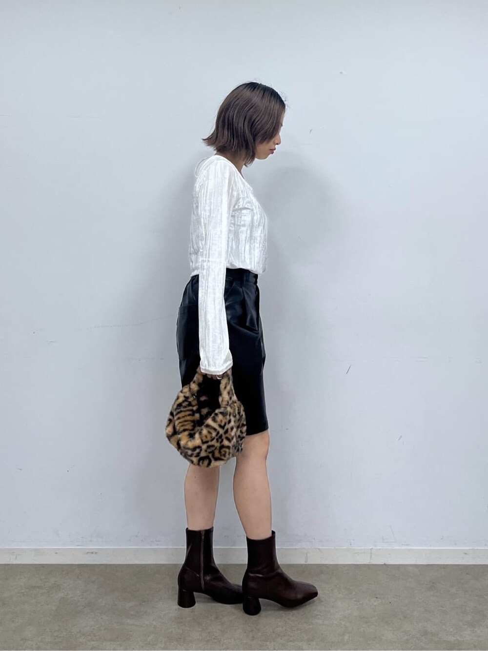 ホワイト系のTシャツ/カットソー、ブラック系のその他パンツ、ブラウン系のハンドバッグを着用したレディースの秋コーディネートの3枚目の写真