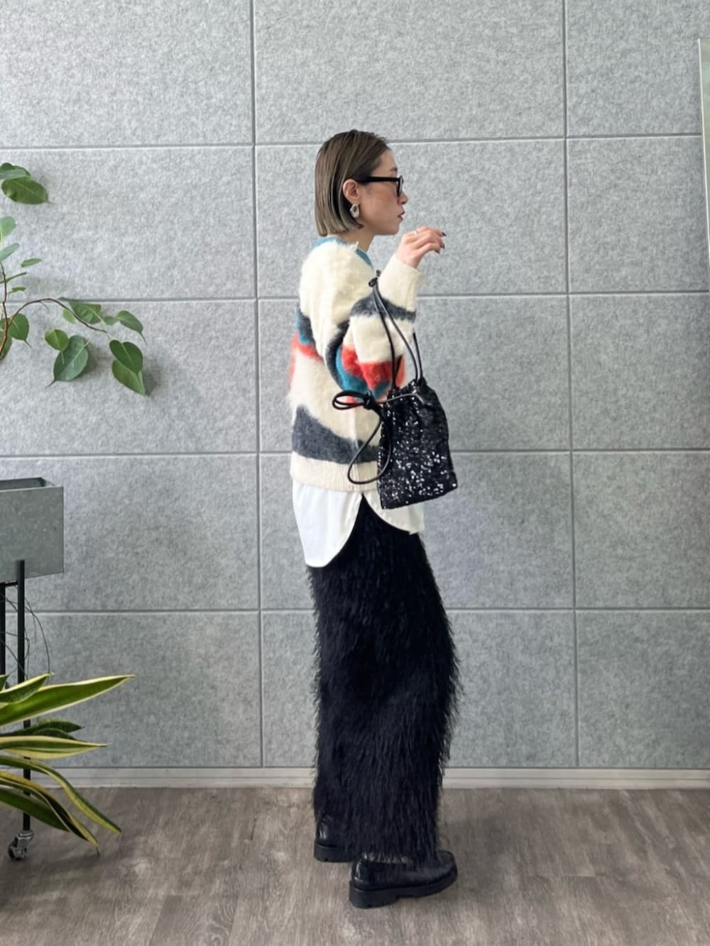 ブラック系のショルダーバッグ、ホワイト系のTシャツ/カットソー、ブラック系のスカートを着用したレディースの冬コーディネートの3枚目の写真