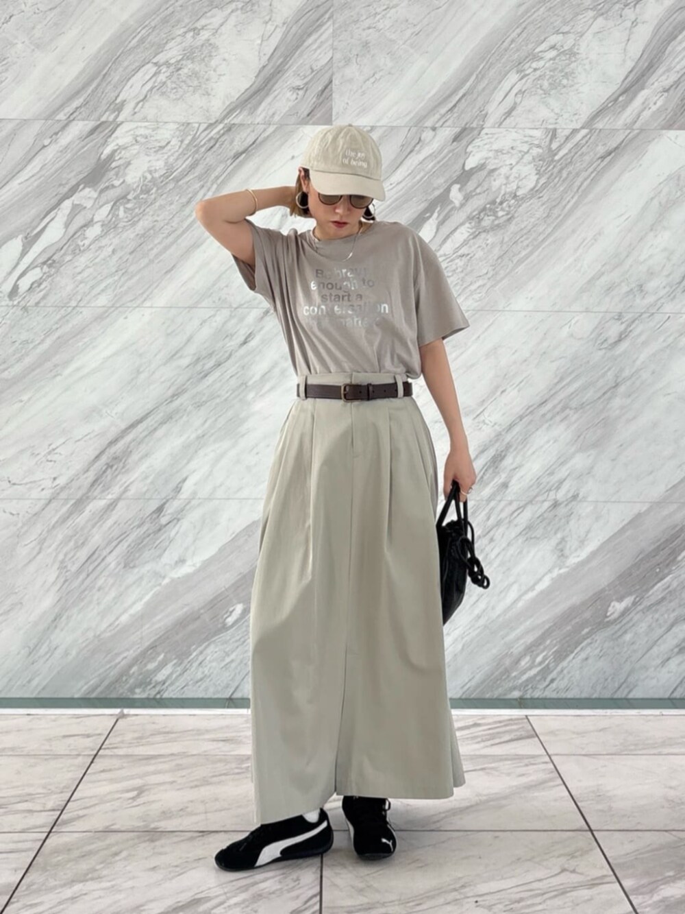 ホワイト系のTシャツ/カットソー、グリーン系のスカートを着用したレディースの春コーディネートの5枚目の写真