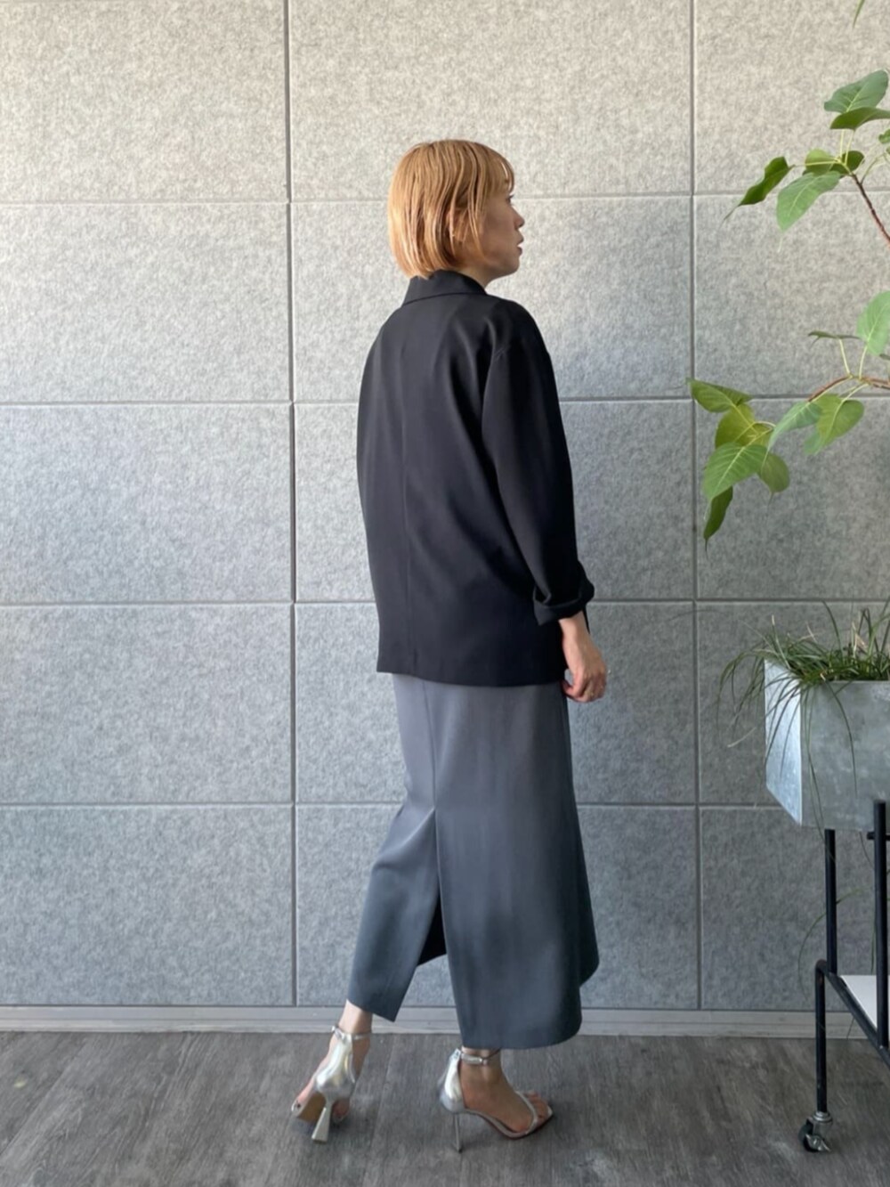 グレー系のワンピース、ブラック系のテーラードジャケットを着用したレディースの春コーディネートの3枚目の写真