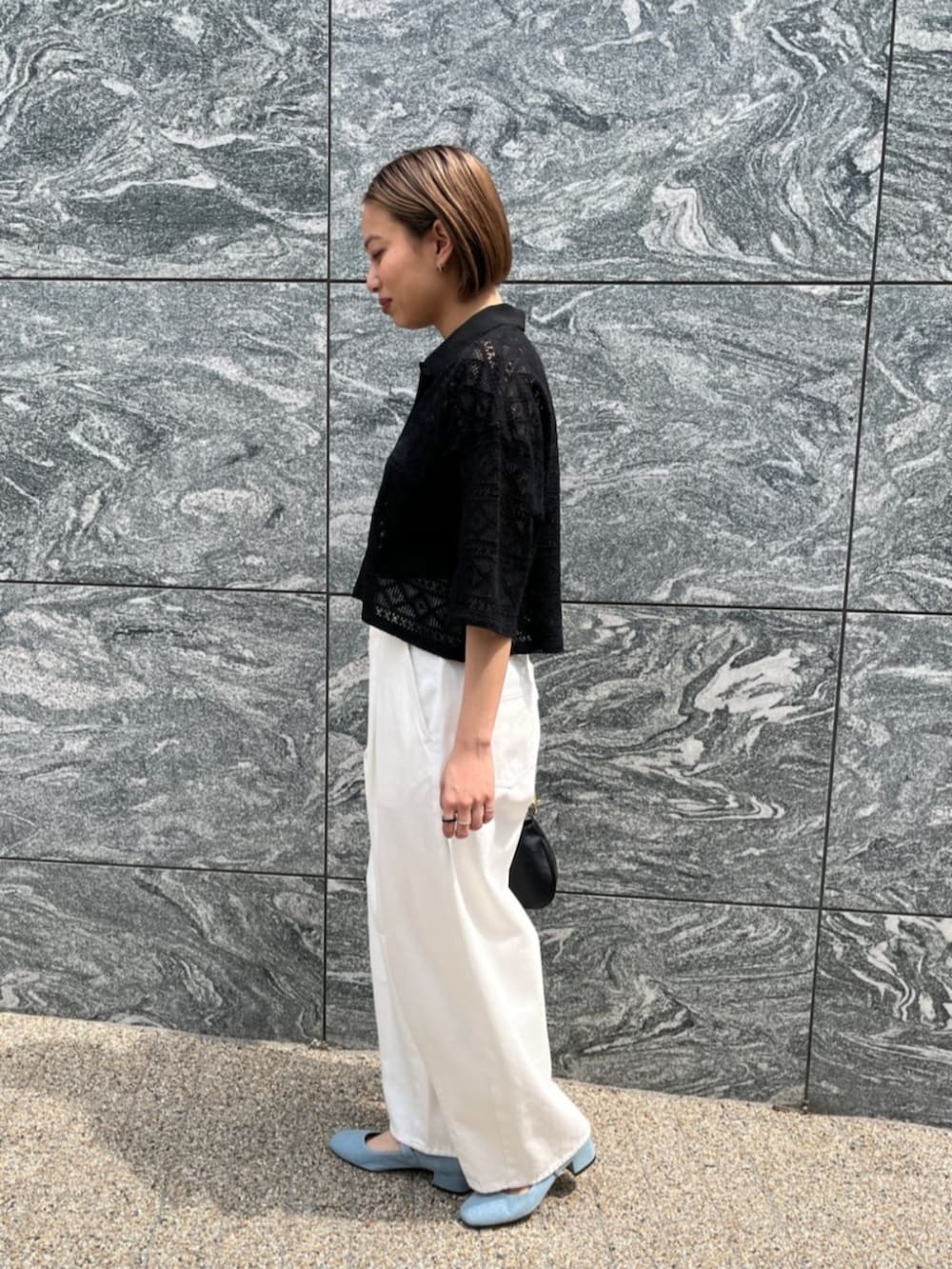 ホワイト系のデニムパンツ、ブラック系のハンドバッグ、ブラック系のシャツ/ブラウスを着用したレディースの夏コーディネートの3枚目の写真