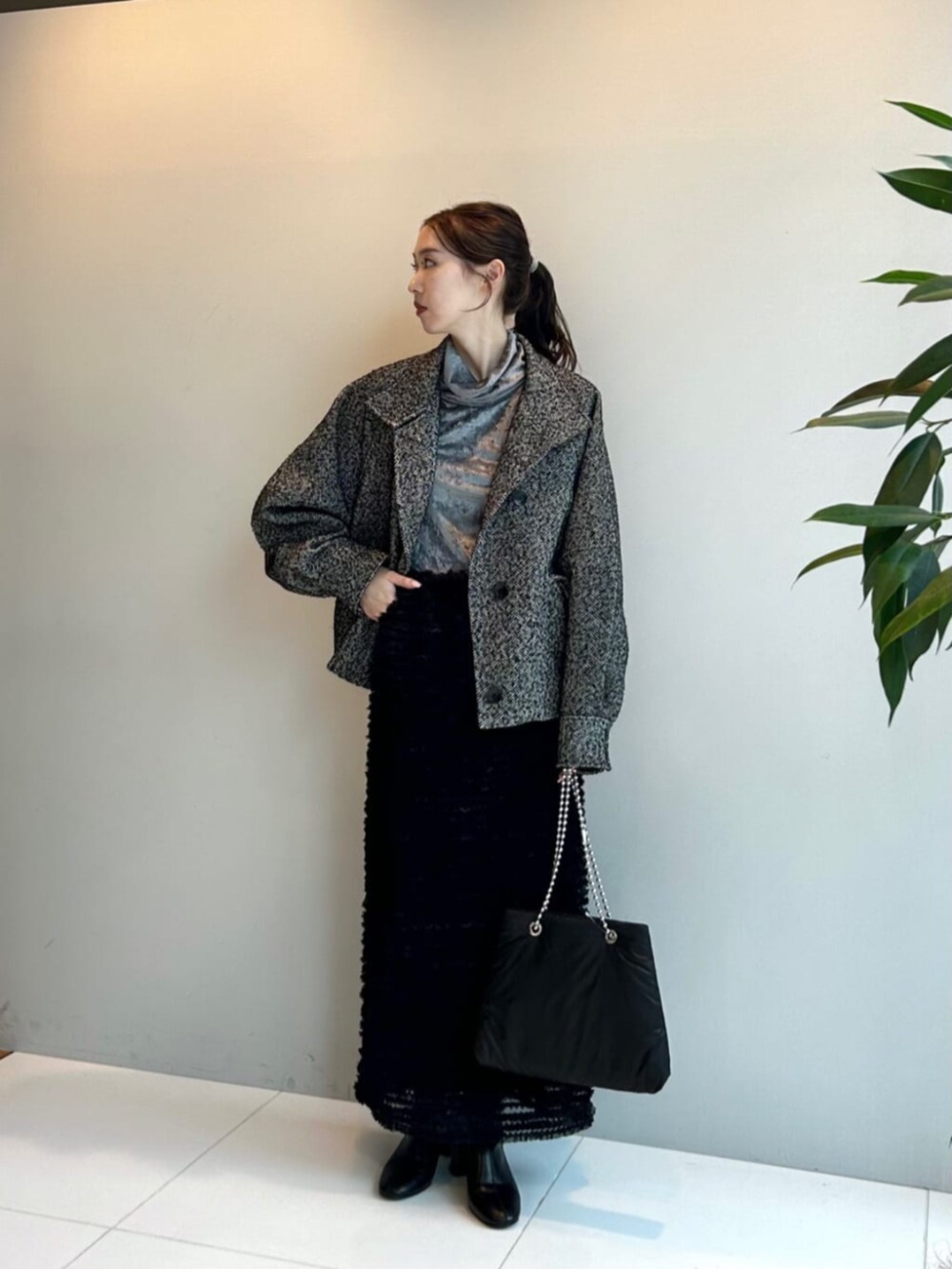 ブラック系のスカート、ブラック系のその他アウター、グレー系のTシャツ/カットソーを着用したレディースの秋コーディネートの2枚目の写真