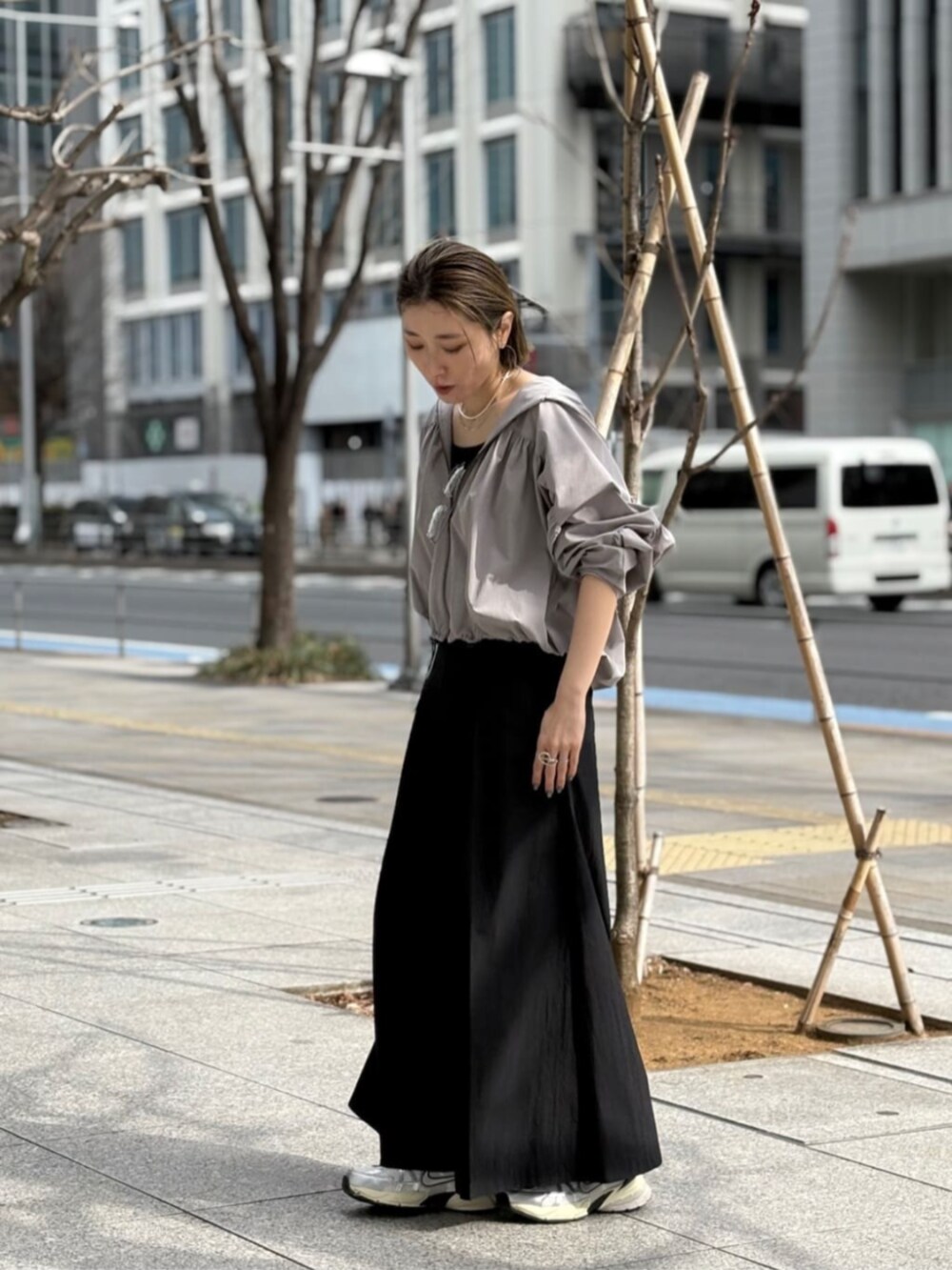 グレー系のブルゾン、シルバー系のタンクトップ、ブラック系のその他パンツを着用したレディースの春コーディネートの2枚目の写真