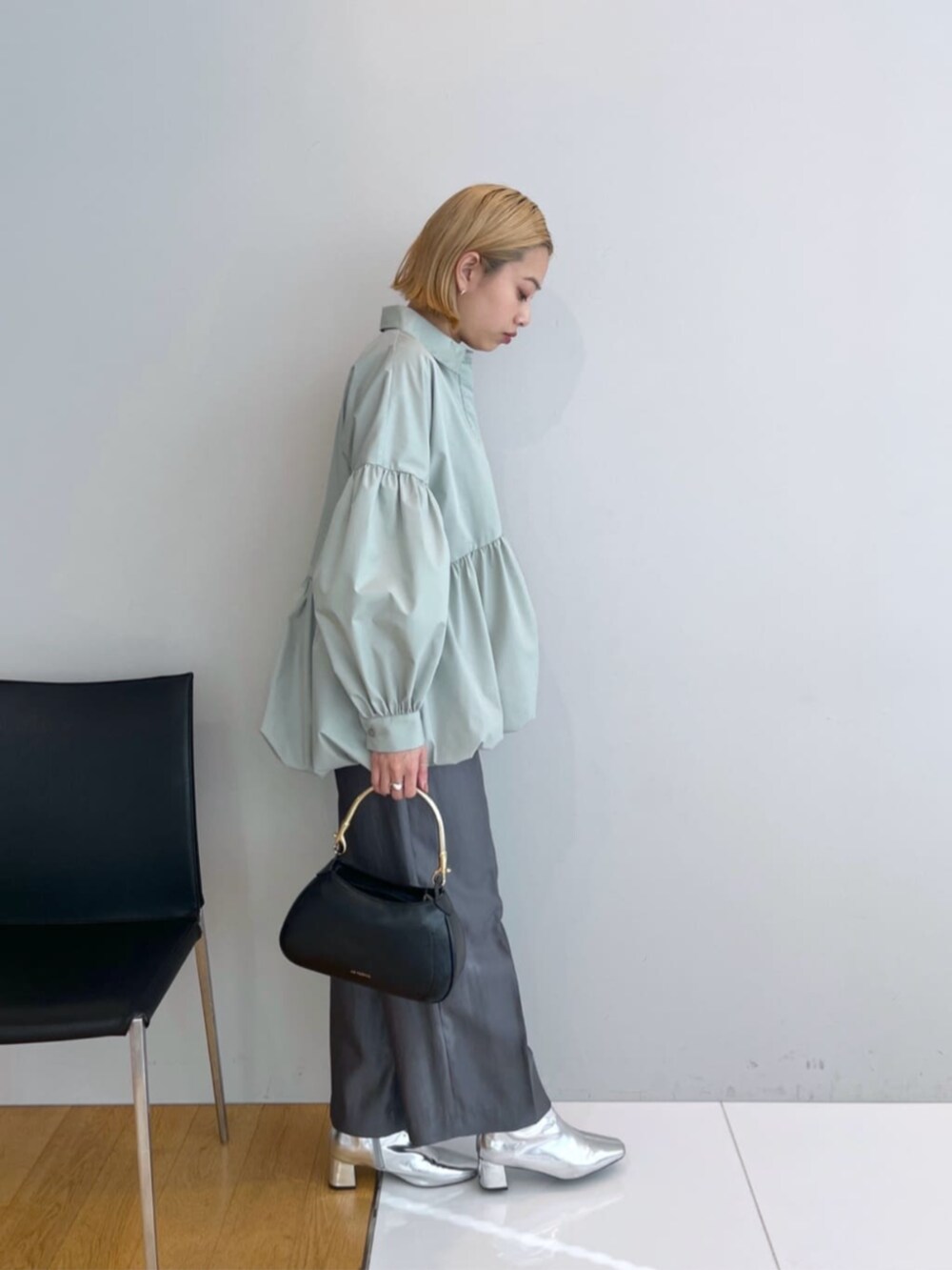 グレー系のその他パンツ、グリーン系のシャツ/ブラウス、ブラック系のハンドバッグを着用したレディースの春コーディネートの2枚目の写真